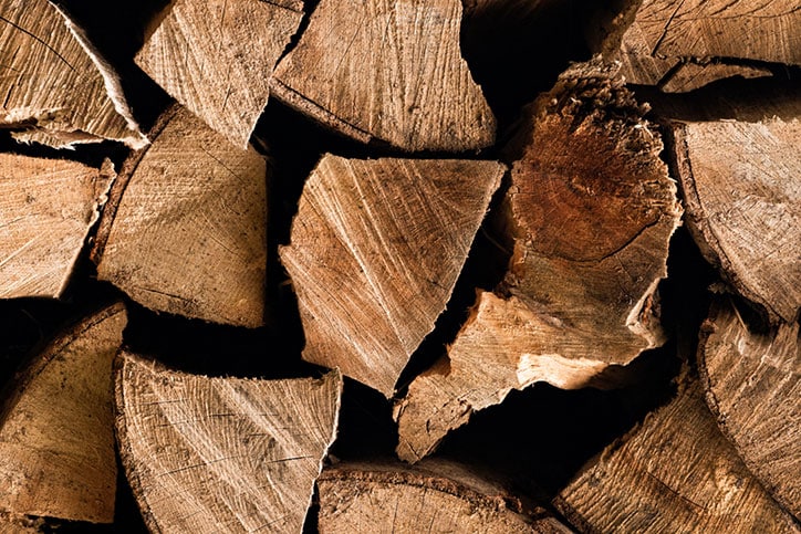 A close-up of stacked, split firewood.